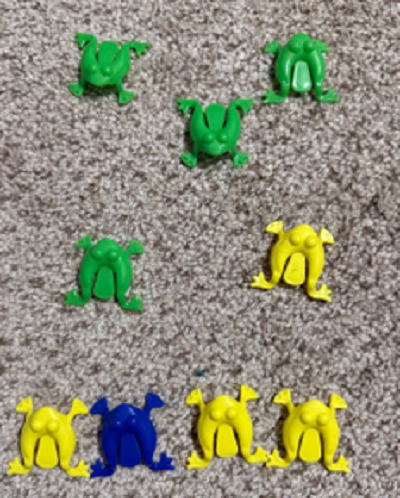 4 green and 1 yellow frogs lined up like five
dots on a dice and 3 yellow and one black frogs in a line below